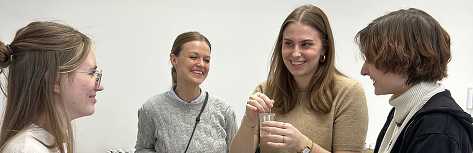 4 Frauen stehen lächelnd in einem Kreis
