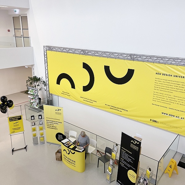 Ein Infopoint mit großem Plakat in der NDU