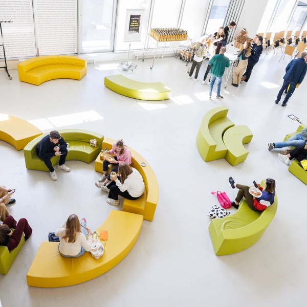 Eine Gruppe sitzt verteilt auf Couches