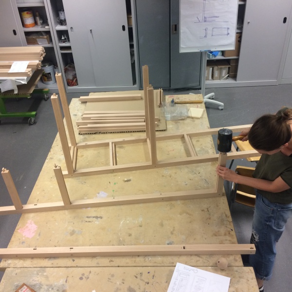 Eine Frau baut ein Regal zusammen