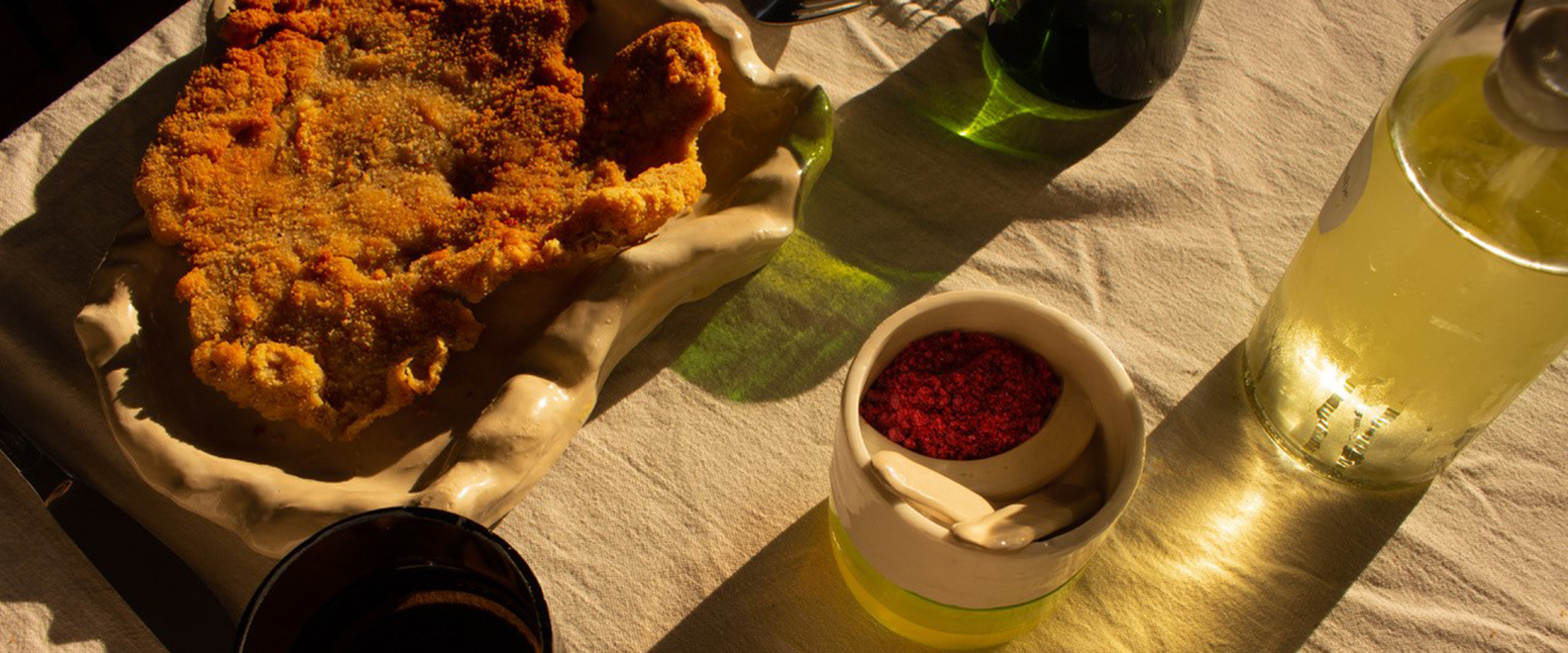 Ein gedeckter Tisch mit Getränken und einem Schnitzel