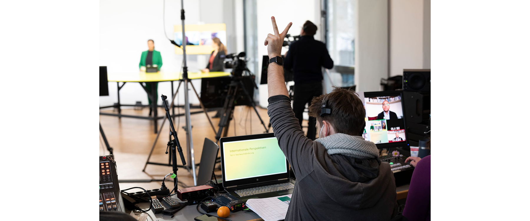 Friedrich Reiß, der zwei Finger hochhält, währen der auf einen Laptop vor ihm sieht