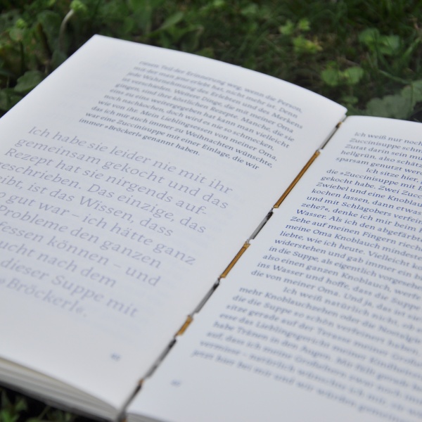 ein aufgeschlagenes Buch liegt in der Wiese