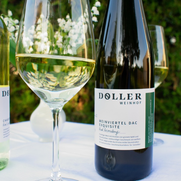 Wein und halbvolles Weinglas stehen auf einem Tisch mit weißer Tischdecke