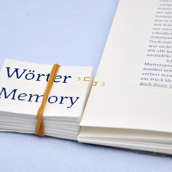 Bachelorarbeit - der Stapel mit der Aufschrift »Wörter Memory« liegt neben einem Buch auf einem blauen Stoffuntergrund