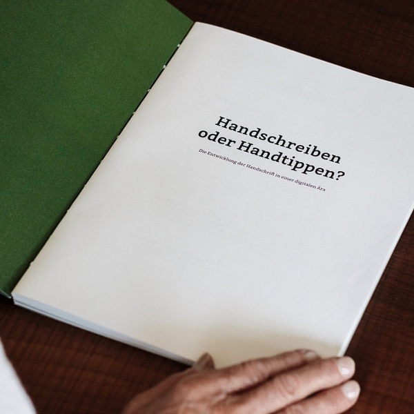 Offenes Buch, in dem "Handschreiben oder Handtippen?" steht