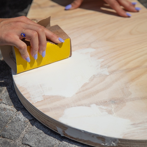 Jemand schleift eine Holzplatte