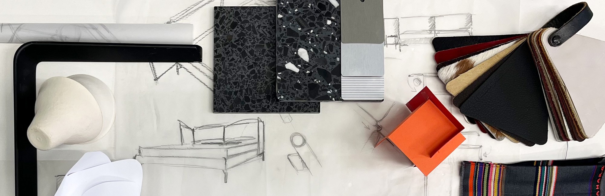 auf einem Spiegelunergrund steht eine wei&szlig;e Box die ge&ouml;ffnet ist, auf dem unteren Teil der Box steht eine schwarze Kugel aus Glas mit einem goldenen horizontalen Strich, der Deckel der Box liegt links daneben und es befindet sich der Schriftzug "momenzz" darauf