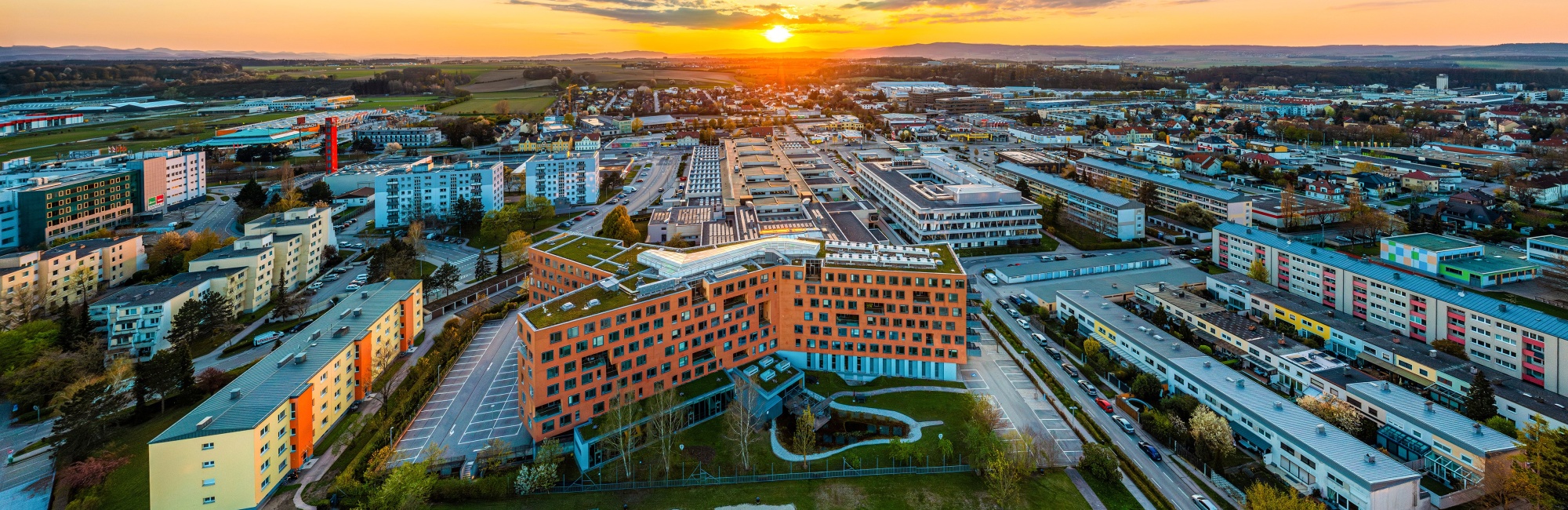 Das WKO NÖ Gebäude von oben mit einem Sonnenuntergang im Hintergrund