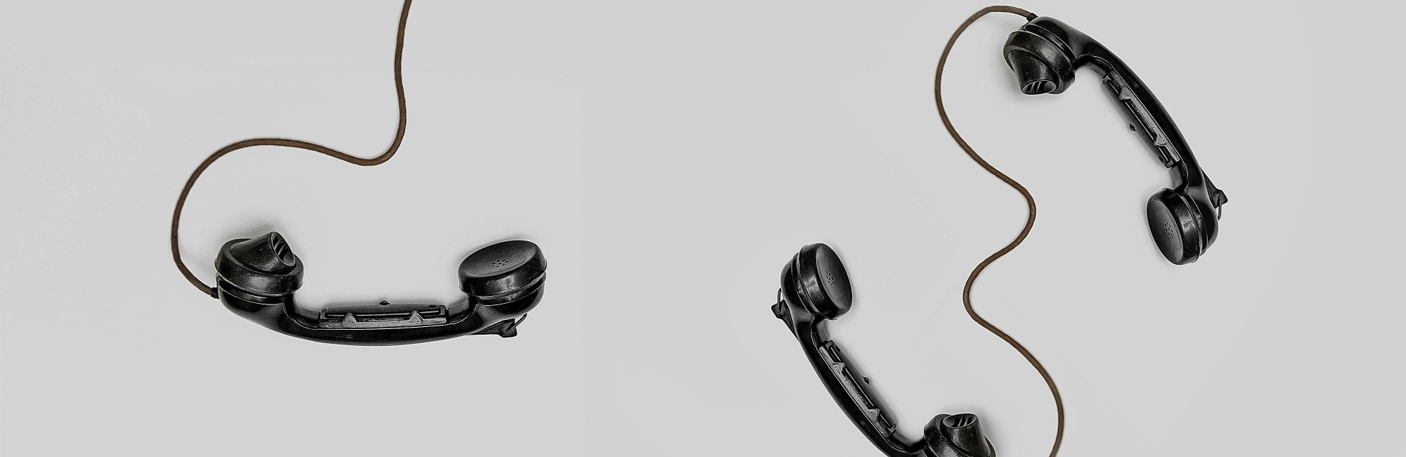 schwarze kabeltelefone auf weißem Hintergrund