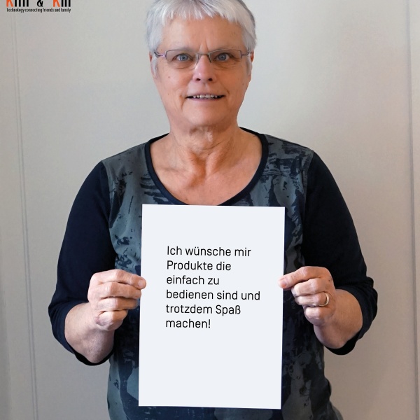 Frau h&auml;lt ein Blatt, auf dem Steht "Ich w&uuml;nsche mir Produkte, die einfach zu bedienen sind und trotzdem Spa&szlig; machen!"