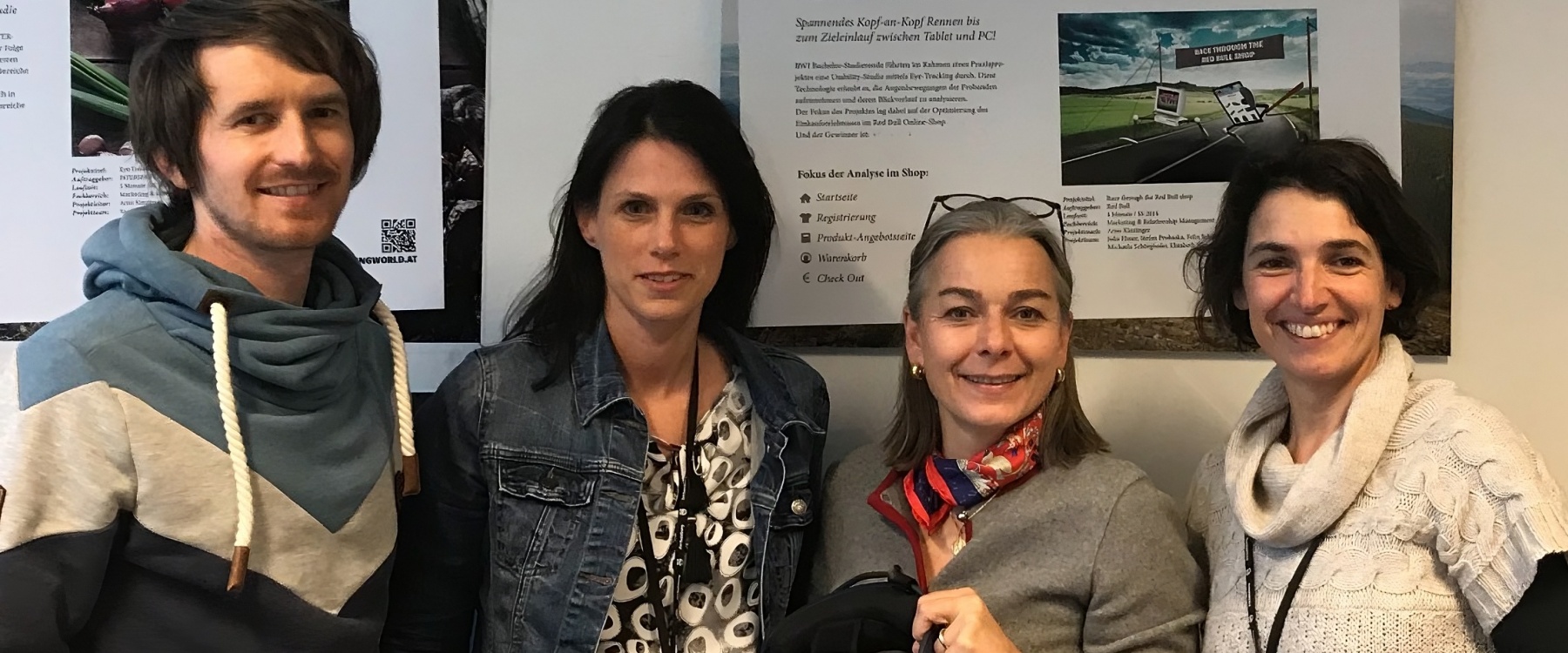 Drei Frauen und ein Mann lächeln in die Kamera